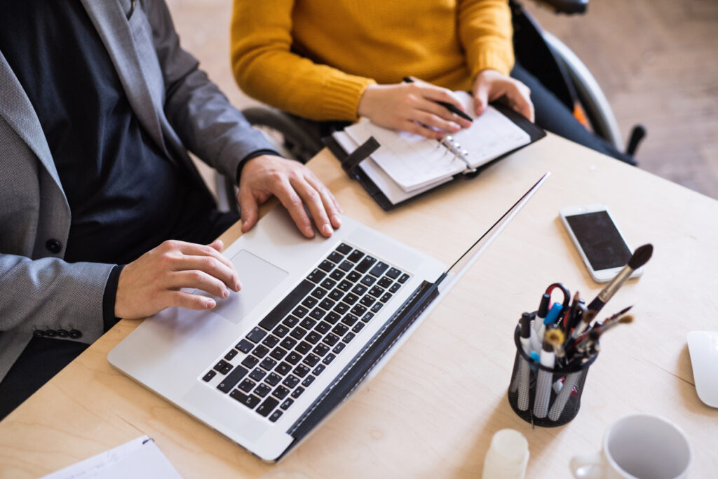 Px photo id two unrecognizable business people in the office working together a man and woman in a wheelchair consulting a project