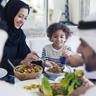 emirati family having lunch together with mom sharing food with son