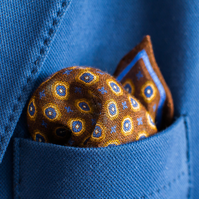 brown color pocket square placed in an elegant blue suit