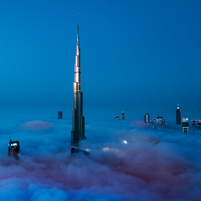 burj khalifa shown along with other skyscraper buildings in te clouds