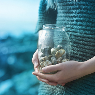Woman holding jar of pebbles close up