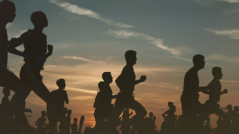 group of men running marathon at dawn
