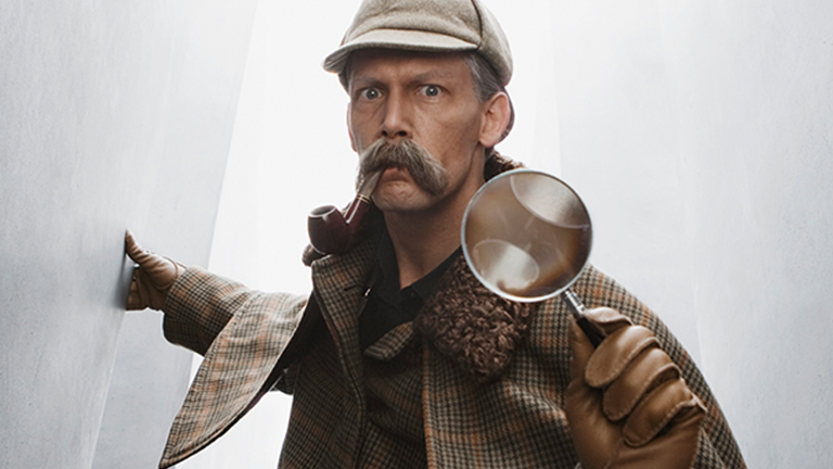 old man having moustache and holding magnifying glass in his hand