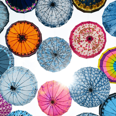 various floral umbrellas shown as decoration in the air symbolising variety of retirement plans
