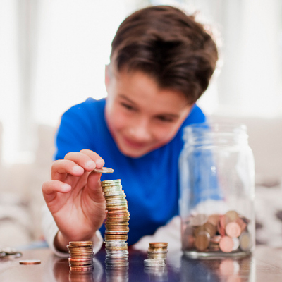 young boy piling up coins which are taken from the coin jar