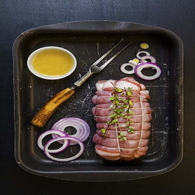 Px photo id raw roast beef ready to be put in the oven with red onion and olive oil on tray