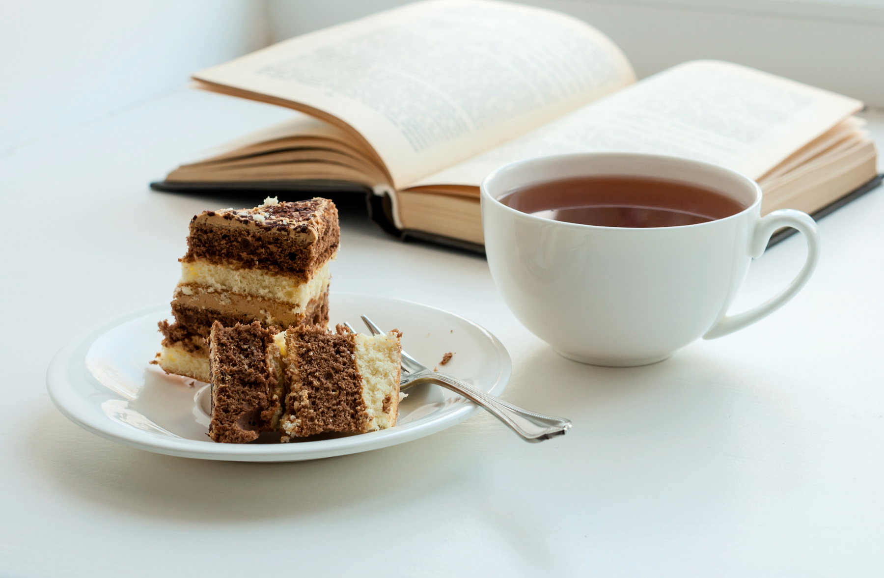 Px photo id cup of tea cake and some books to read lying on the table