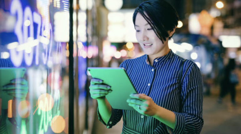 Businesswoman checking stock market data on tablet