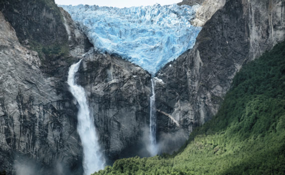 A huge Glacier melts to result in a huge waterfall splashing down the face of the Andes Mountains
