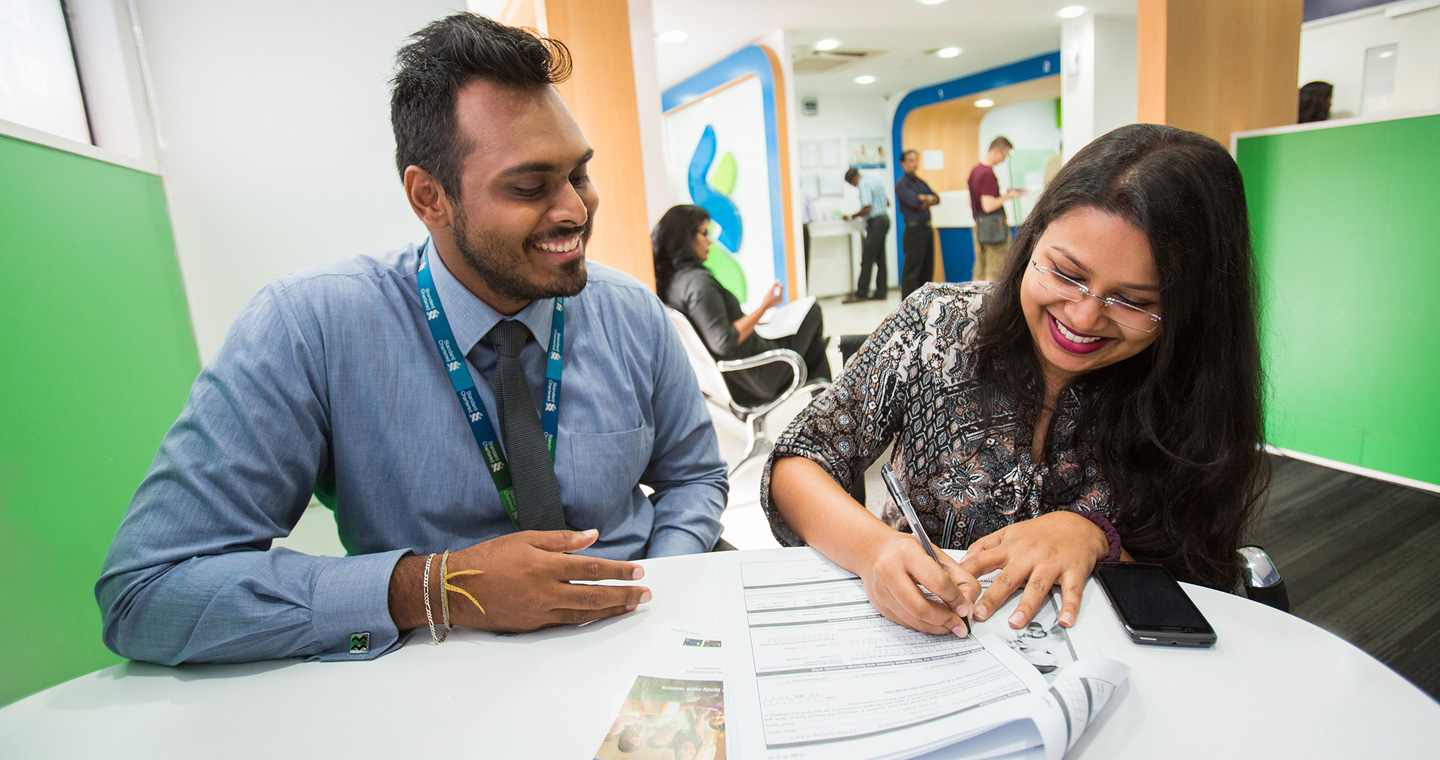 Member of Standard Chartered helping a customer in a socially responsible way