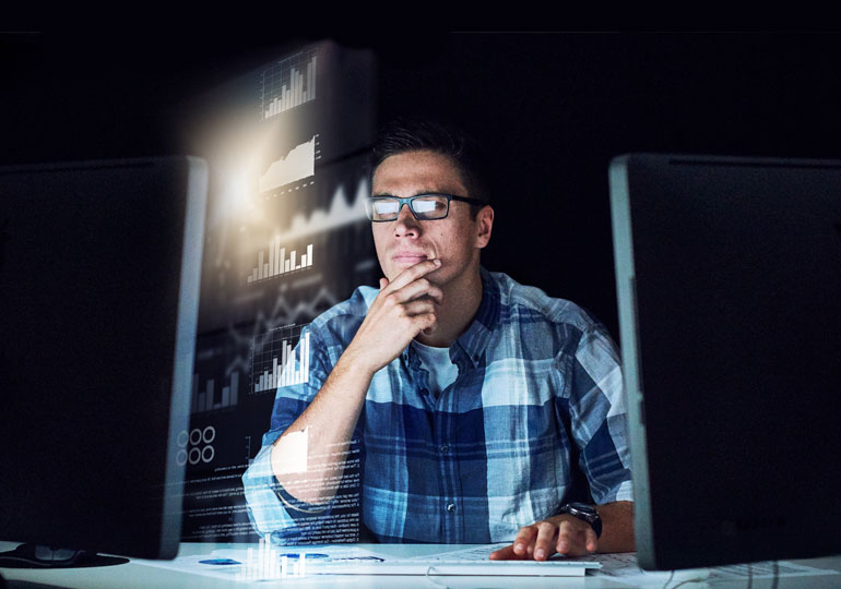 man using desktop computer in dark room
