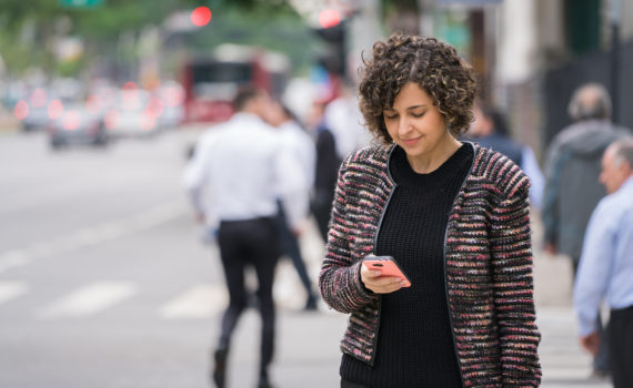 Woman looking at phone in street