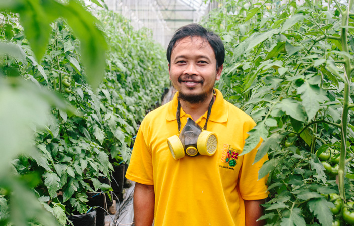 Man smiling in greenhouse