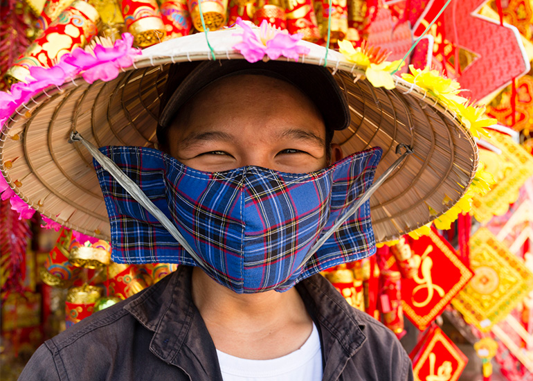 Person in sunhat and cloth face mask