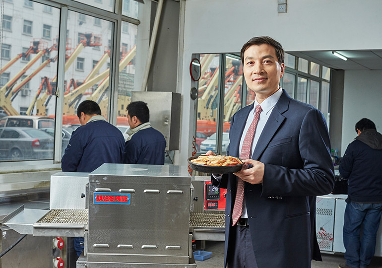 man holding pie in front of machines
