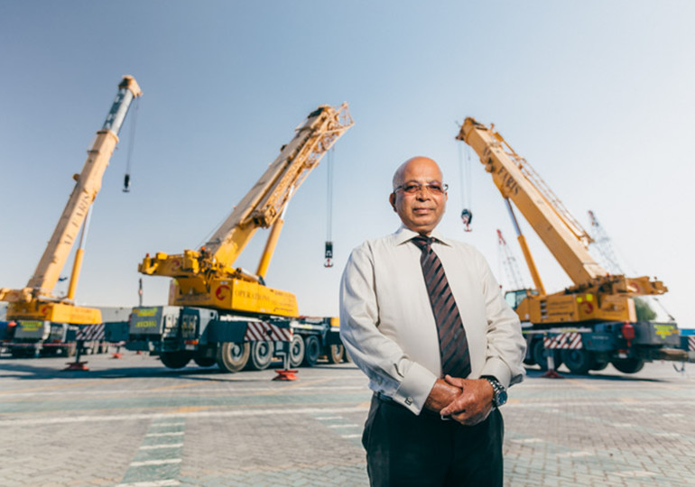 man standing in front of cranes
