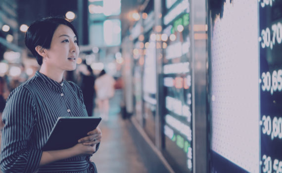 Lady looking at stock board holding a tablet