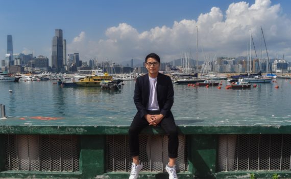 William Luk sitting in front of harbor