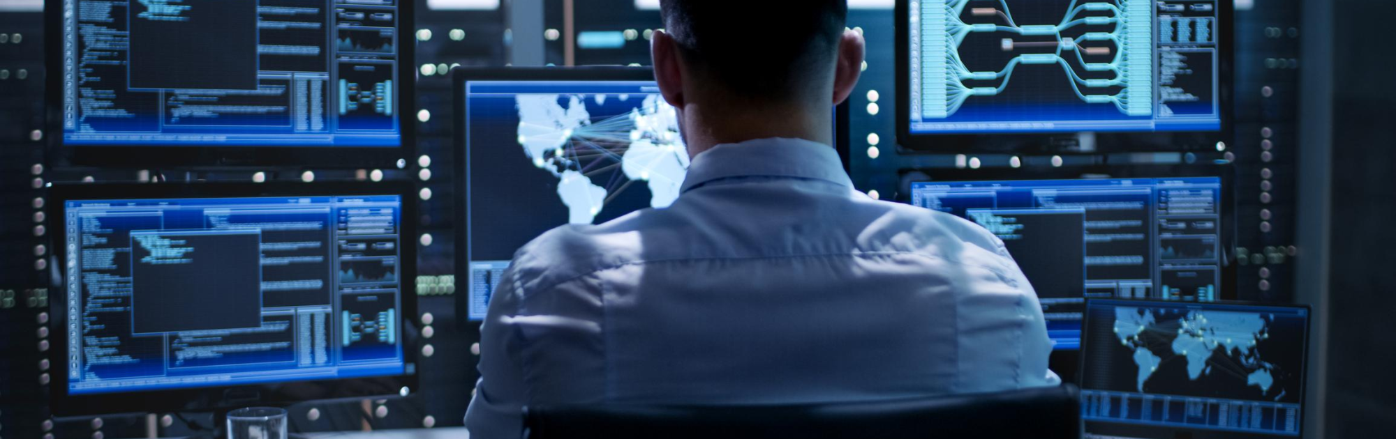 Man looking at bank of computer screens