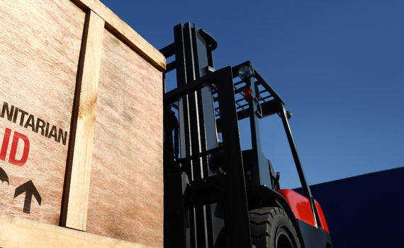 Large wooden box labelled “Humanitarian Aid” on a forklift