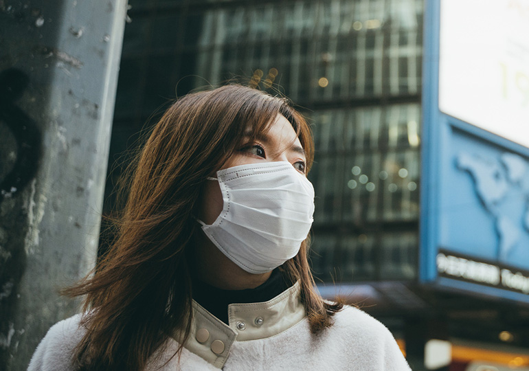 Women protecting herself with a face mask in Asia