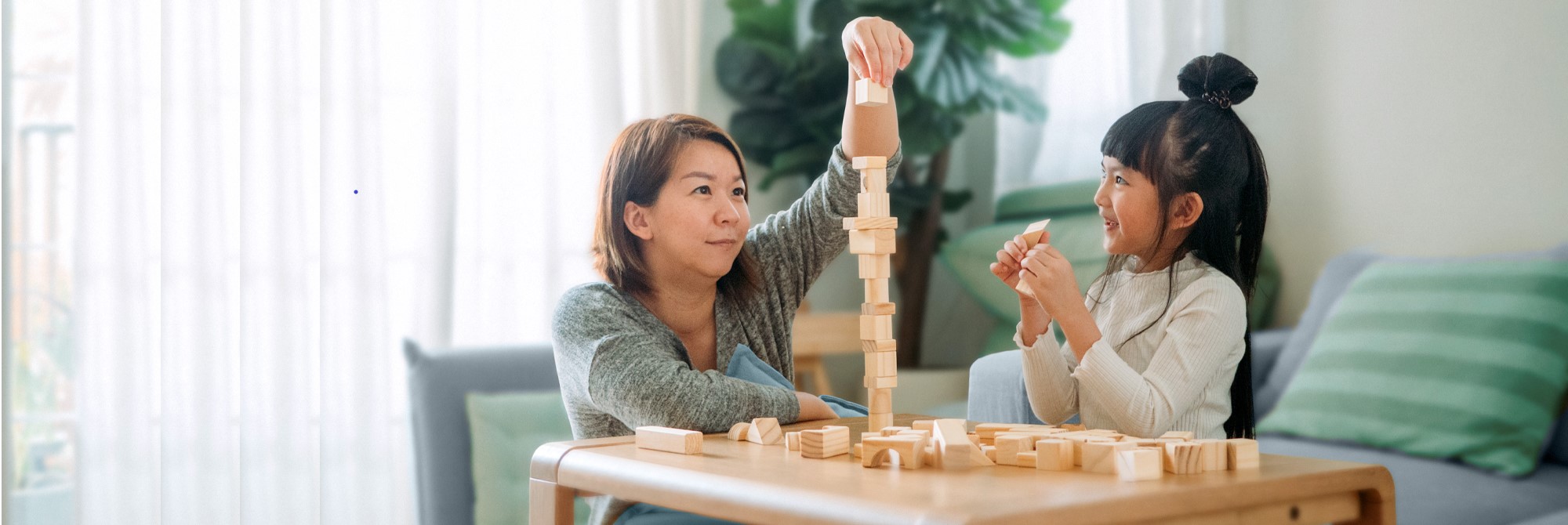 Wealth management: Mother and child playing with wooden blocks