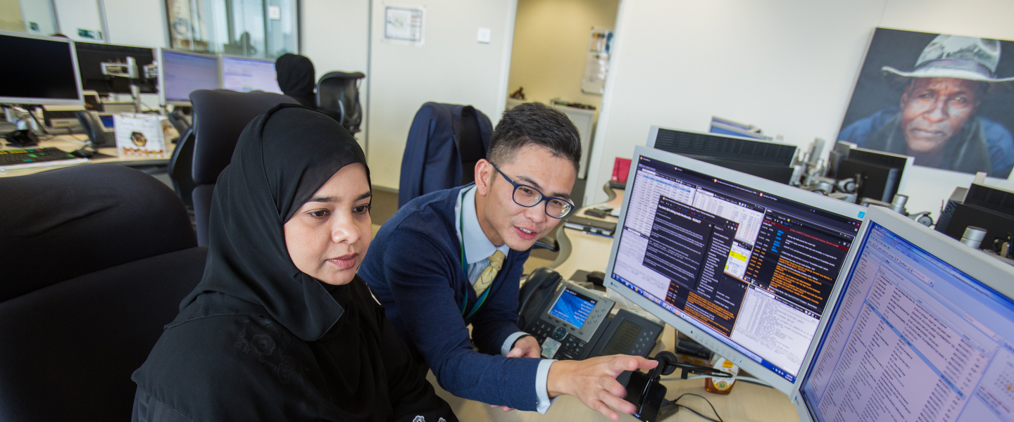 2 people working together at computer