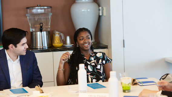 two students talking at a table