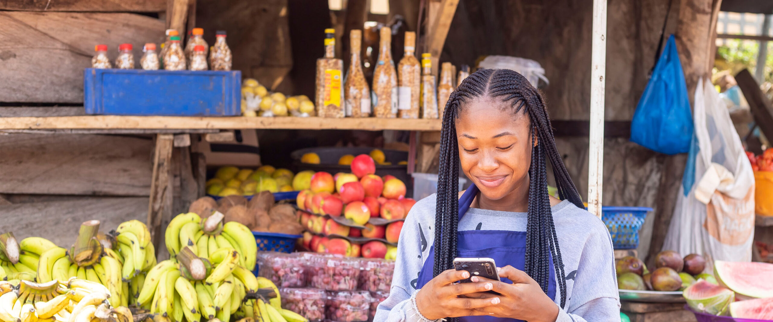 A market trader uses her mobile phone for online banking.