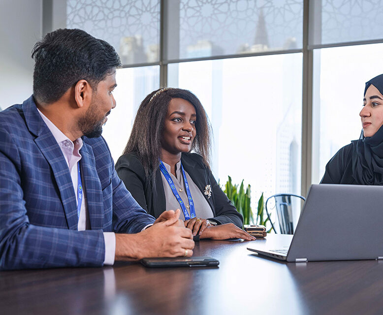 A group of colleagues chat in the office of Standard Chartered Dubai.