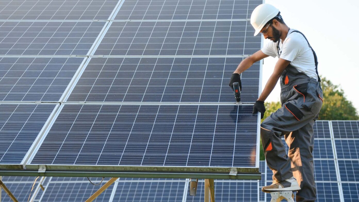 A man works on a solar panel.