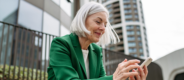 A woman reviews emails on her phone.