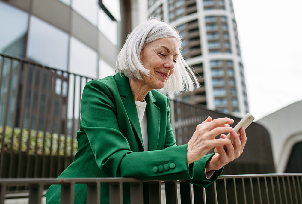 A woman reviews emails on her phone.