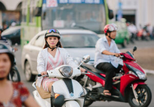 woman riding moped in traffic