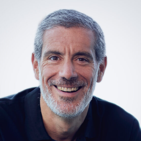 Alex Manson, the CEO of SC Ventures, smiling against a grey background.