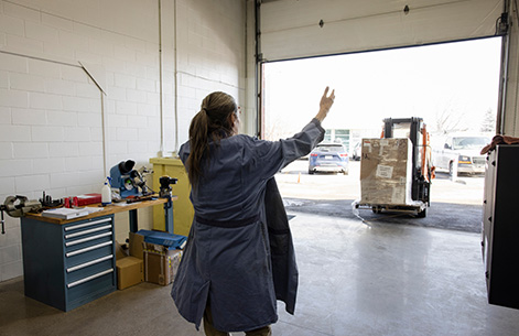 A woman guides a forklift truck.