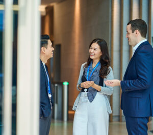 Colleagues laugh in an office foyer.