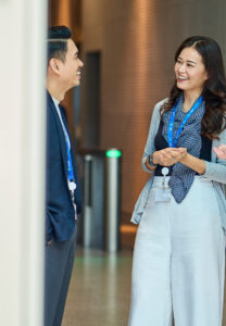 Colleagues laugh in an office foyer.