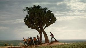 Children running past a tree