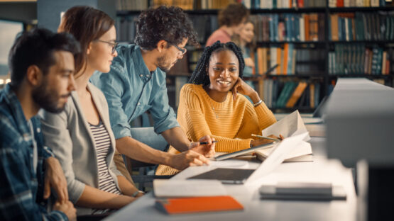 People talking with books and papers in front of them