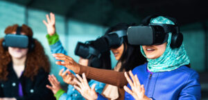 A group of girls play with VR headsets.