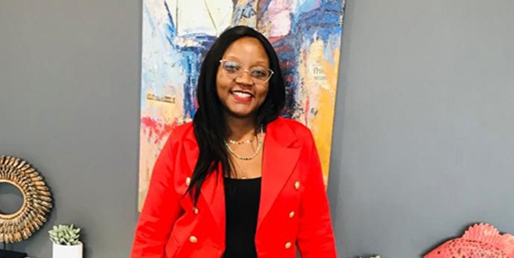 Gloria smiling and wearing a red jacket.