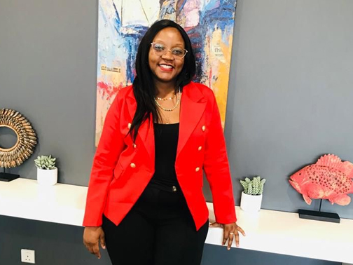 Gloria smiling and wearing a red jacket