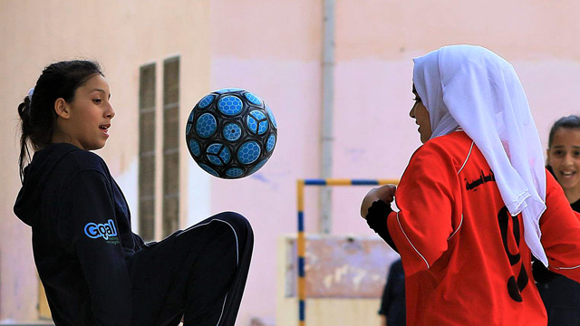 Goal girls practise football skills together.