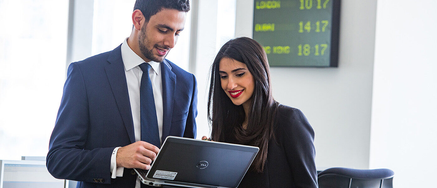 Ma and woman looking at laptop and smiling