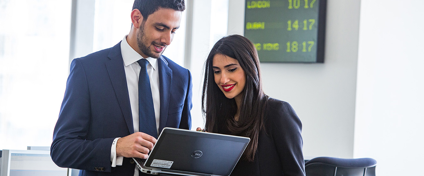 Ma and woman looking at laptop and smiling