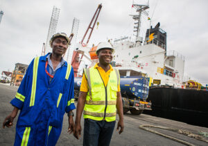 construction workers in front of ship