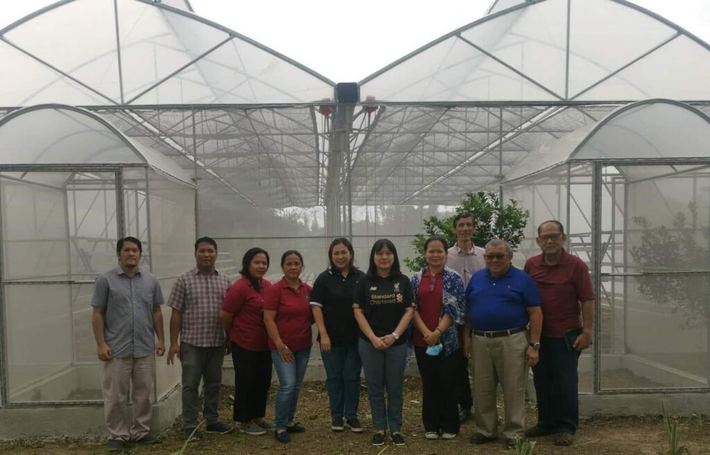 The SC team stand with agriculture school team by the facility