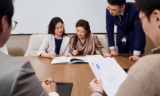 Standard Chartered colleagues work together in a meeting room.