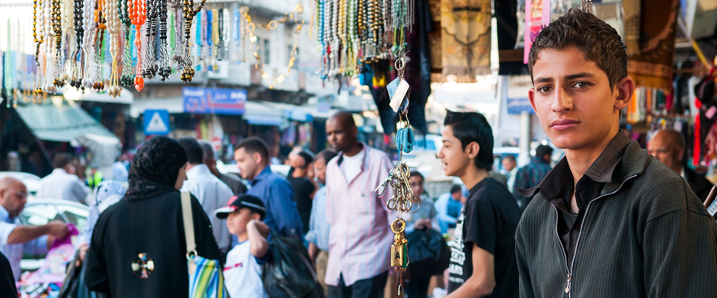 man working at stall on busy street